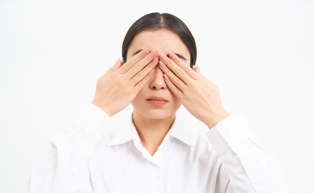 갑작스러운 눈 밑 떨림으로 불편함을 느끼며 눈 주변을 만지고 있는 환자의 모습