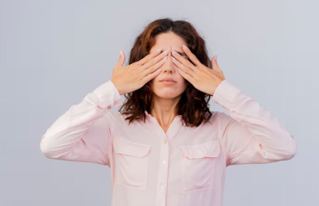 시야 속 검은 점이나 눈의 불편함으로 인해 눈을 감싸고 고민하는 여성